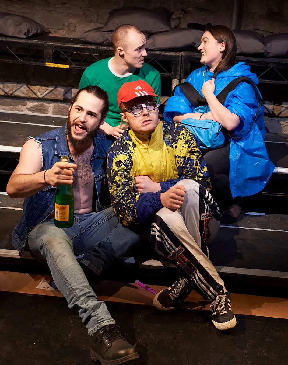 4 people sitting on steps drinking in the show Transporting Live